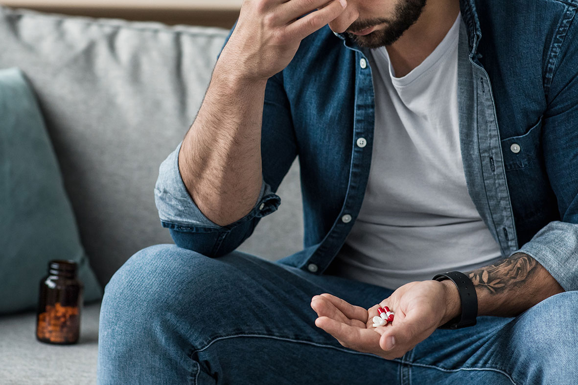 Junger Mann nimmt Medizin gegen Depressionen